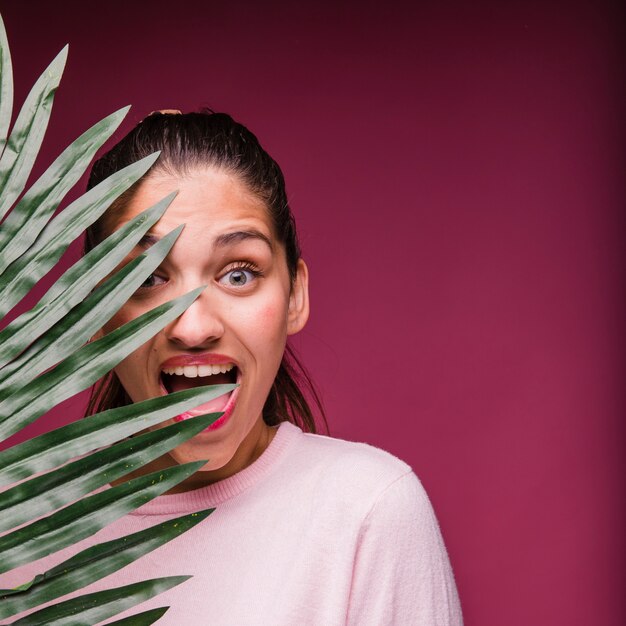 Chica morena con hoja tropical