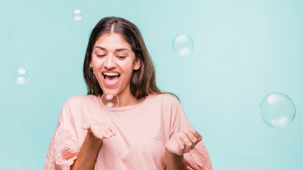 Chica morena jugando con burbujas de jabón