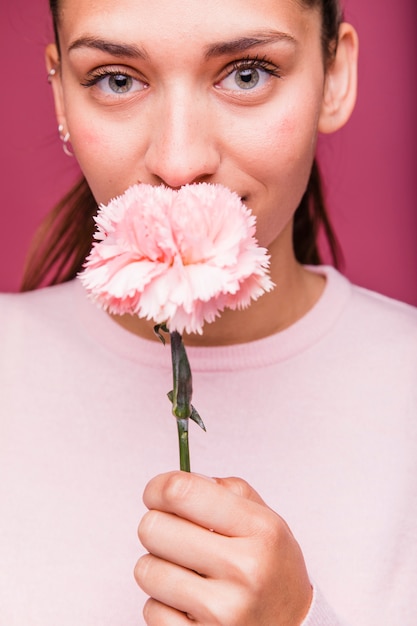 Foto gratuita chica morena posando con clavel