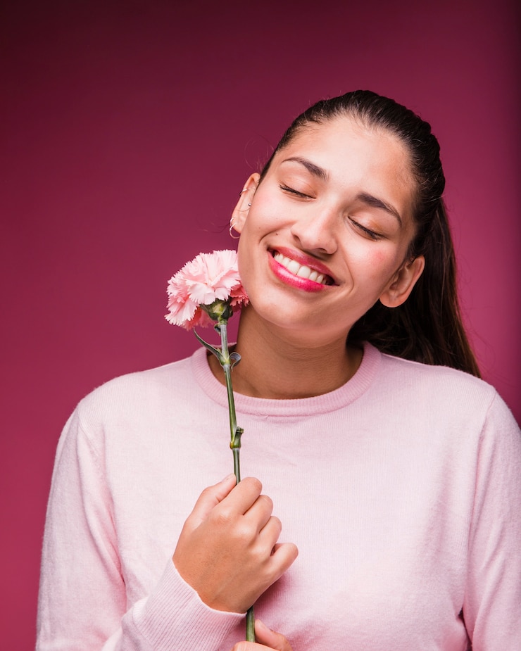 Foto gratuito chica morena posando con clavel