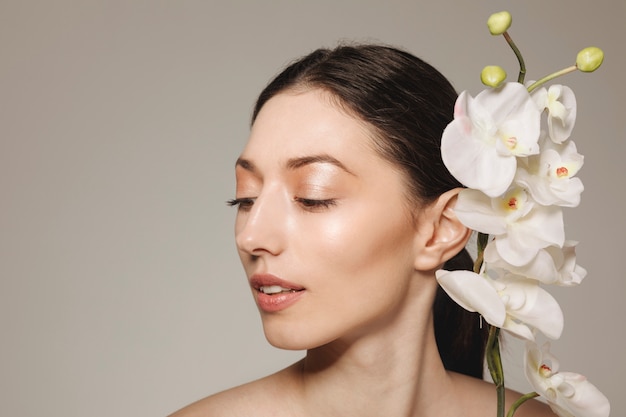 Foto gratuita chica morena posando con flores