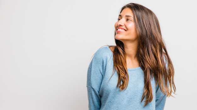 Chica morena posando con un jersey azul