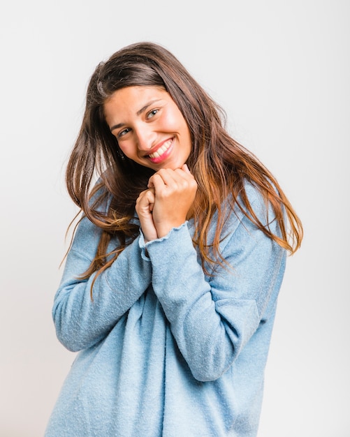 Chica morena posando con un jersey azul