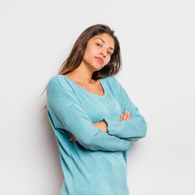 Chica morena posando con un jersey azul