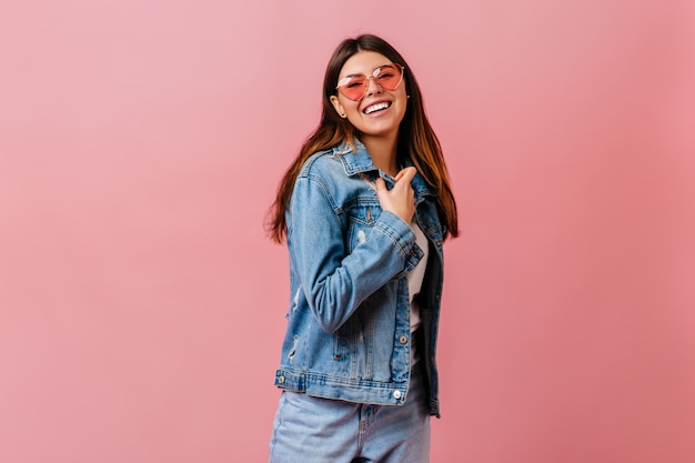 Chica morena refinada en jeans mirando a cámara. Foto de estudio de mujer de buen humor viste chaqueta vaquera.