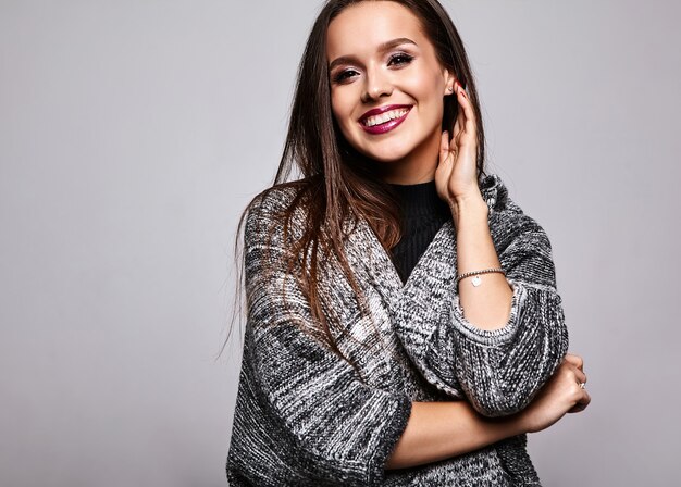 chica morena en ropa casual suéter cálido en gris con maquillaje de noche y labios coloridos