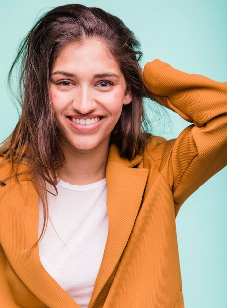 Chica morena sonriente posando con abrigo