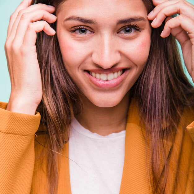 Chica morena sonriente posando con abrigo