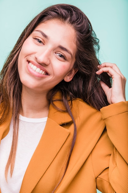 Chica morena sonriente posando con abrigo