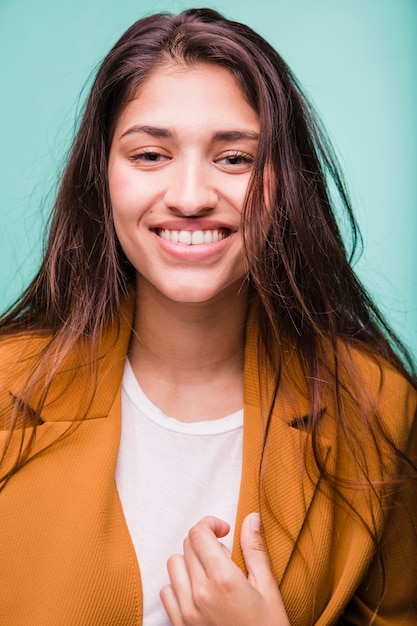 Foto gratuita chica morena sonriente posando con abrigo