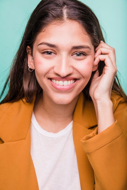 Chica morena sonriente posando con abrigo