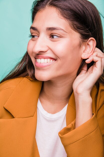 Chica morena sonriente posando con abrigo