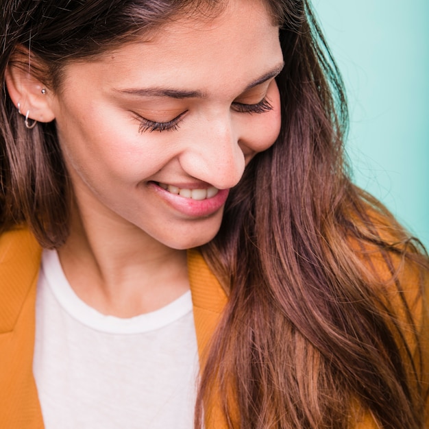 Chica morena sonriente posando con abrigo