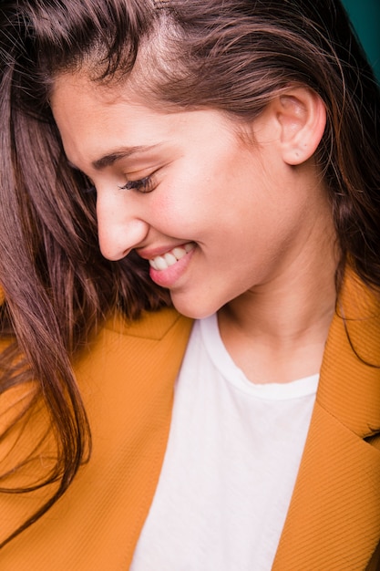 Chica morena sonriente posando con abrigo