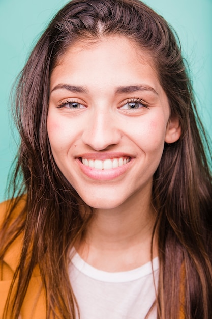 Chica morena sonriente posando con abrigo