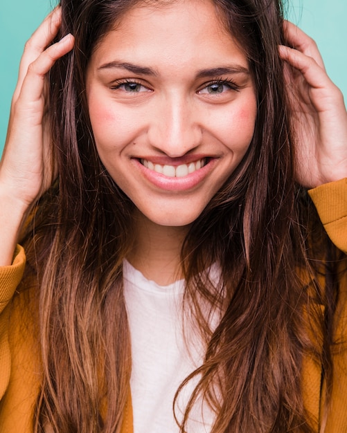 Chica morena sonriente posando con abrigo