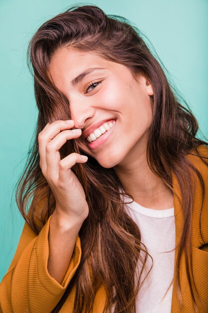 Chica morena sonriente posando con abrigo