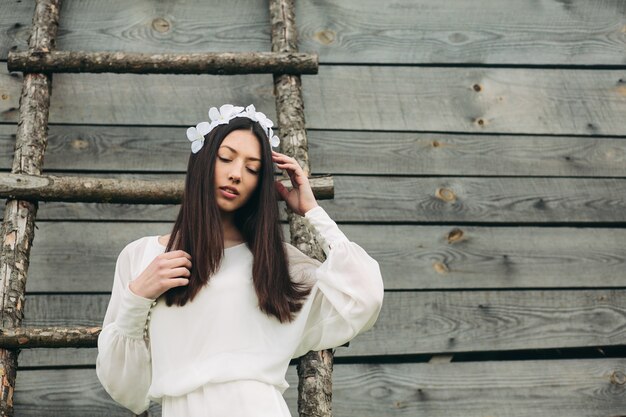 Chica morena con vestido blanco y corona floral