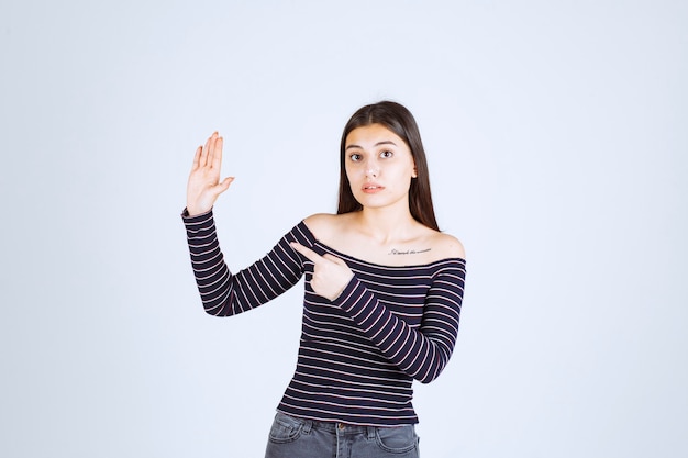 Chica mostrando algo en su mano abierta.