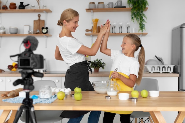 Chica y mujer preparando comida tiro medio