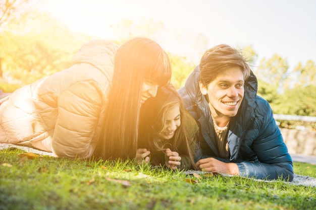 Chica muy feliz disfrutando en el parque con su madre y su padre