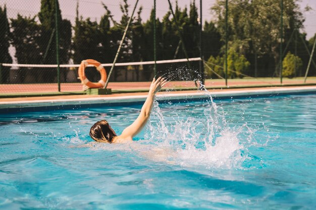 Chica nadando a crol en piscina