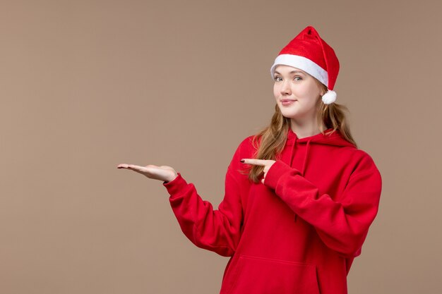 Chica de Navidad vista frontal con capa roja en el espacio marrón