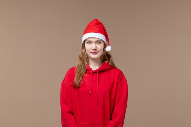 Chica de Navidad vista frontal con capa roja en el espacio marrón