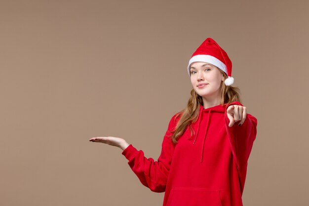 Chica de Navidad vista frontal con capa roja en el espacio marrón