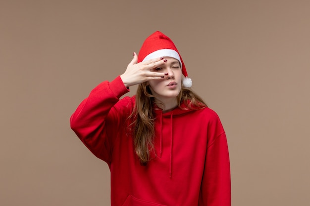 Chica de Navidad de vista frontal posando sobre fondo marrón emoción de Navidad de vacaciones