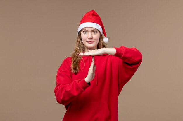 Chica de Navidad de vista frontal posando con una sonrisa en la emoción de Navidad de vacaciones de fondo marrón