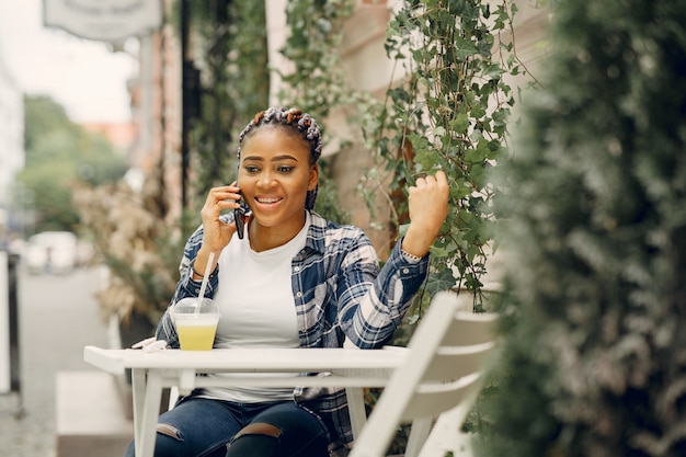 Chica negra en una ciudad de verano con laptop