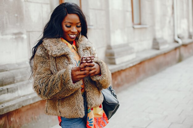 chica negra elegante en una ciudad