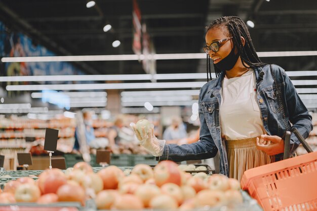 Chica negra con máscara comprar comida