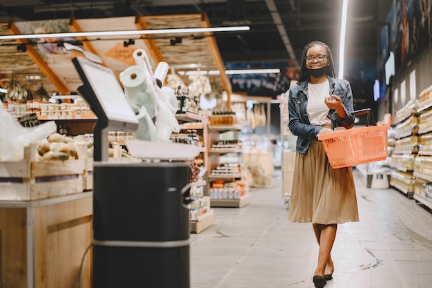 Chica negra con máscara comprar comida