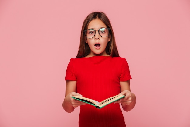 Chica nerd sorprendida mirando mientras lee el libro