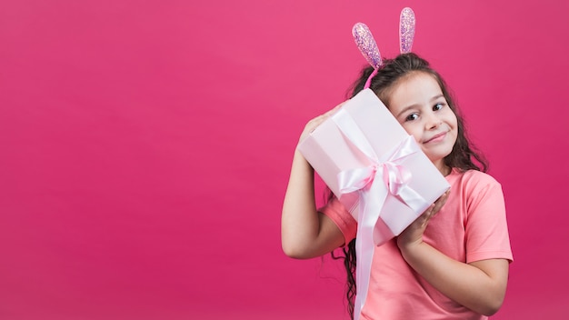 Chica en orejas de conejo con caja de regalo