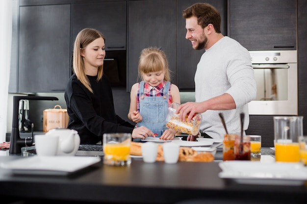 Chica con padres preparando el desayuno