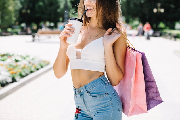 Chica con paquetes de compras tomando café