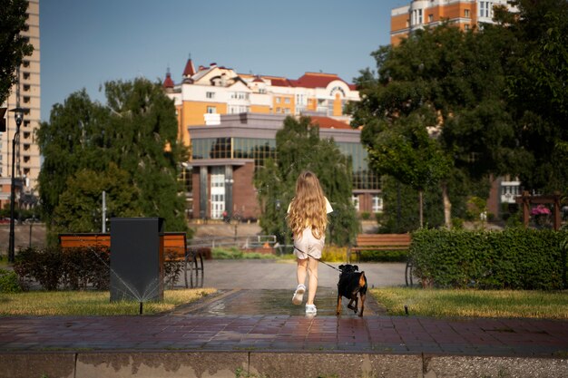 Chica paseando a un perro de tiro largo