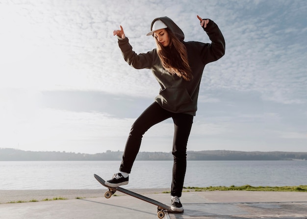 Chica patinador de vista frontal haciendo un truco