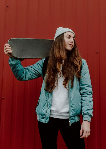 Chica patinadora al aire libre y su patineta