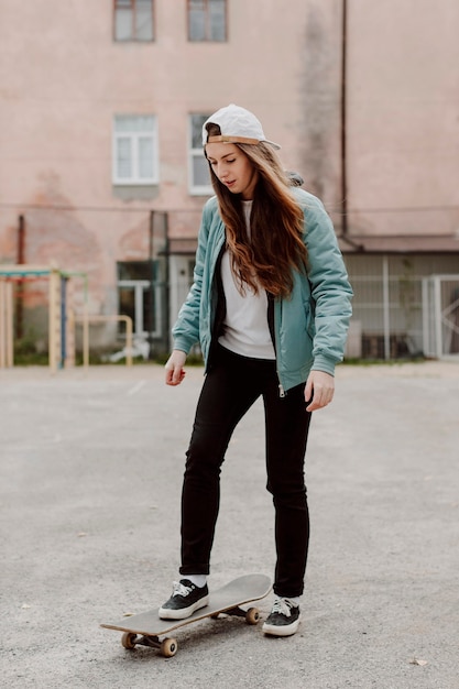 Chica patinadora al aire libre y su patineta