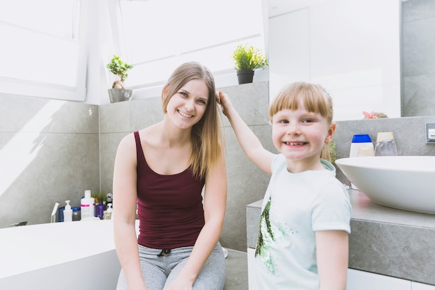 Foto gratuita chica peinando el pelo de la madre