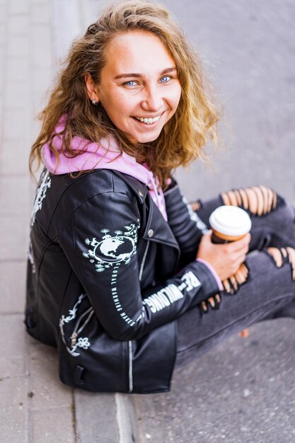 Foto gratuita chica de pelo blanco y rizado con un vaso de café.