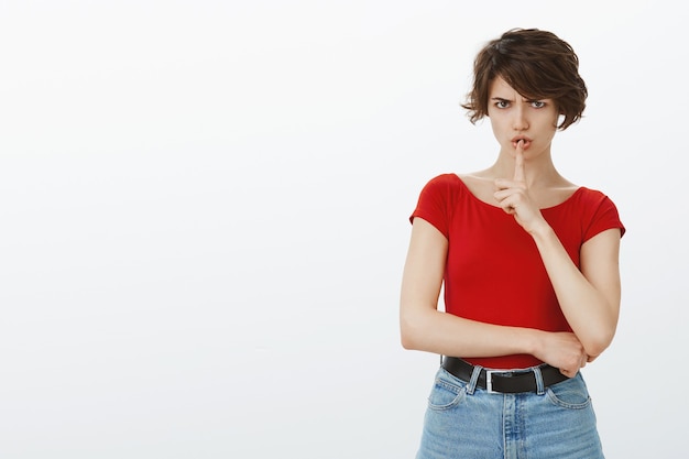 Chica de pelo corto posando en camiseta roja