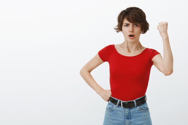 Chica de pelo corto posando en camiseta roja