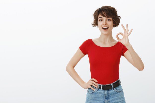 Chica de pelo corto posando en camiseta roja