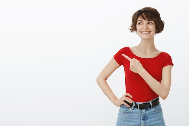 Chica de pelo corto posando en camiseta roja