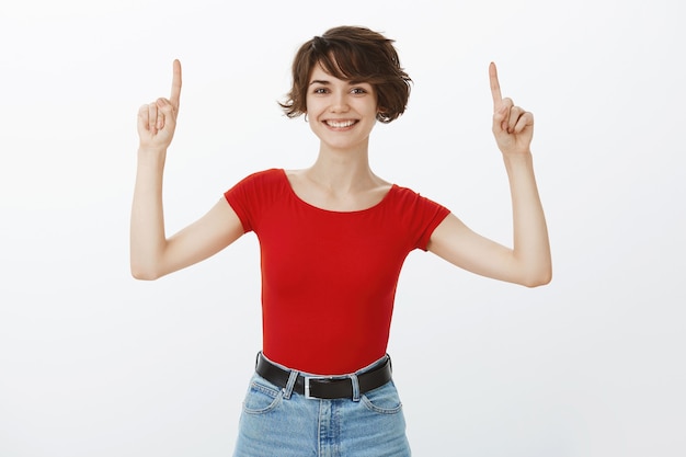 Chica de pelo corto posando en camiseta roja